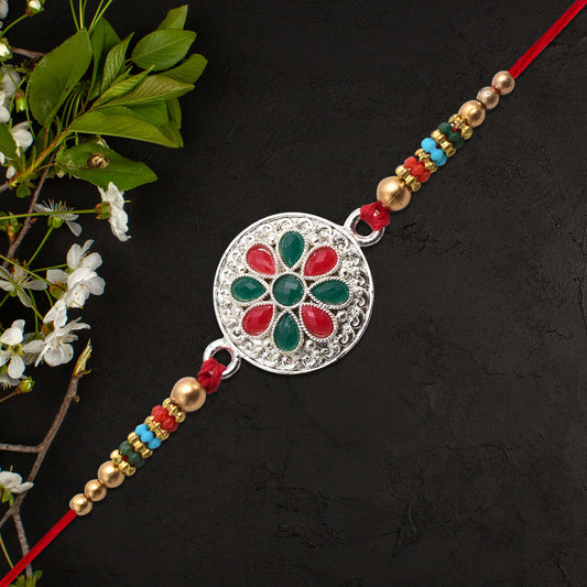 Silver Plated Floral Rakhi With Red Green Stones